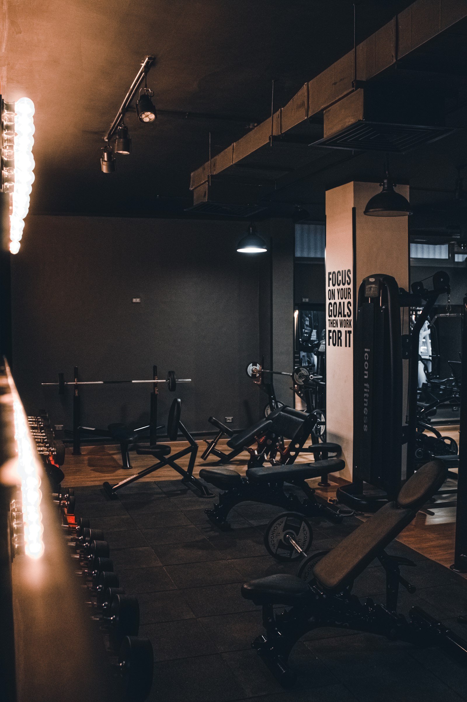 Dark strength-training floor at a VOLT studio, lined with benches, racks and a motivational wall graphic