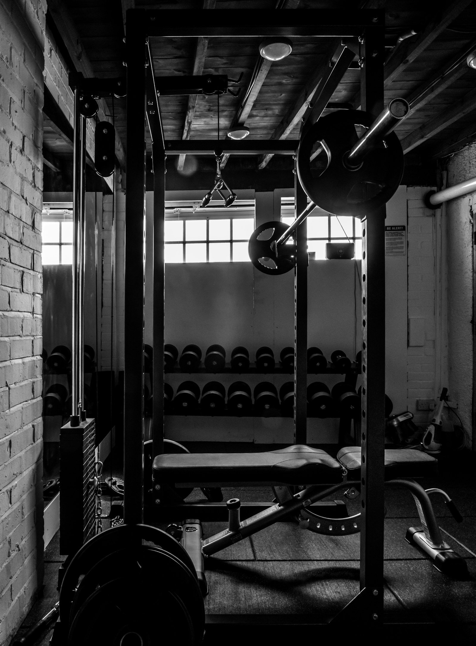 Squat rack and dumbbell wall in the free-weights section of a VOLT studio